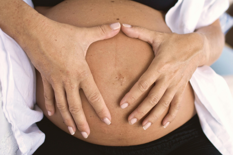 Pregnant Belly with Hands Forming a Heart